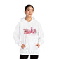 femaie model wearing hope + joy collective white hoodie sweatshirt with "Tis the Season" in cursive font below a graphic image of seasonal coffee and cocoa drinks accented in pink with a pink Christmas tree topped with pink bow