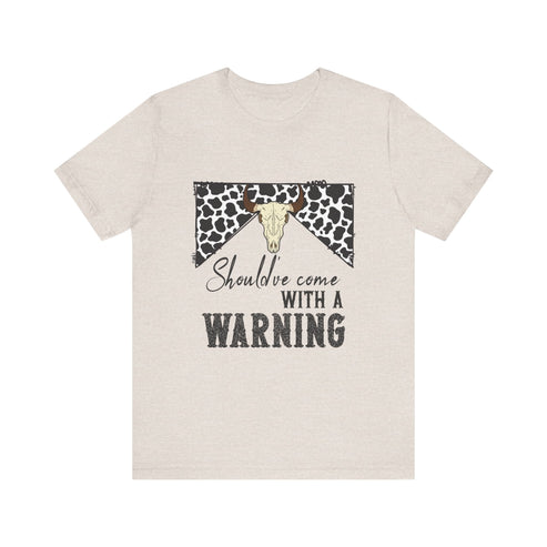 hope + joy collective heather dust short sleeve t-shirt with a graphic image of a leopard banner and cow skull in the middle that says "Should've Come with a Warning" in western font