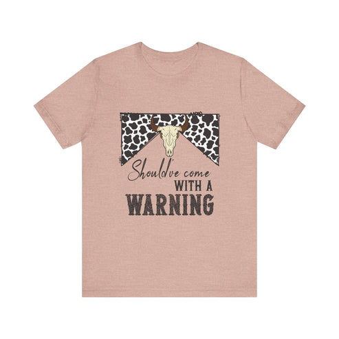 hope + joy collective heather prism peach short sleeve t-shirt with a graphic image of a leopard banner and cow skull in the middle that says "Should've Come with a Warning" in western font