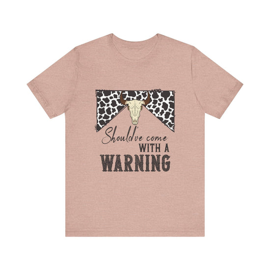 hope + joy collective heather prism peach short sleeve t-shirt with a graphic image of a leopard banner and cow skull in the middle that says "Should've Come with a Warning" in western font