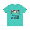hope + joy collective teal short sleeve t-shirt with a graphic image of a leopard banner and cow skull in the middle that says "Should've Come with a Warning" in western font
