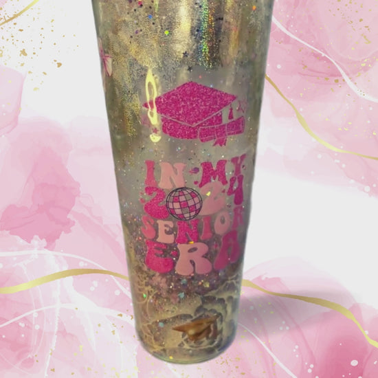 Metallic gold cup celebrating 2024 graduates with pink icons 