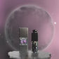 hope and joy collective video of  Moonlit Mischief Lip Gloss tube, black cap and 3D cat on front with rhinestone eyes and labeled box packaging standing on a gray irregular shaped marble stand with a glowing moon in the background and a dark and light purple moving sky with glistening starts.